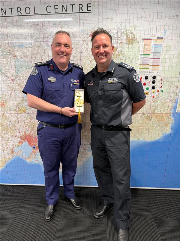 ACFO David Maxwell presenting Chief Officer Jason Heffernan with a gift from Hunan Vocational Institute of Safety Technology